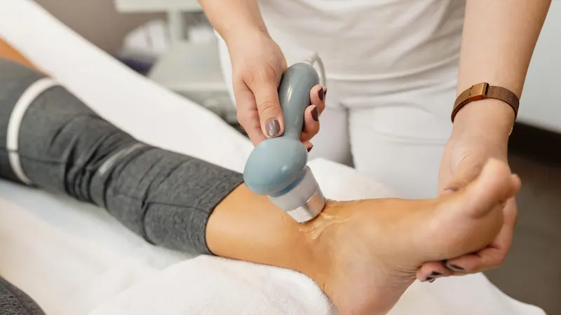 Handheld applicator positioned at a patient’s ankle