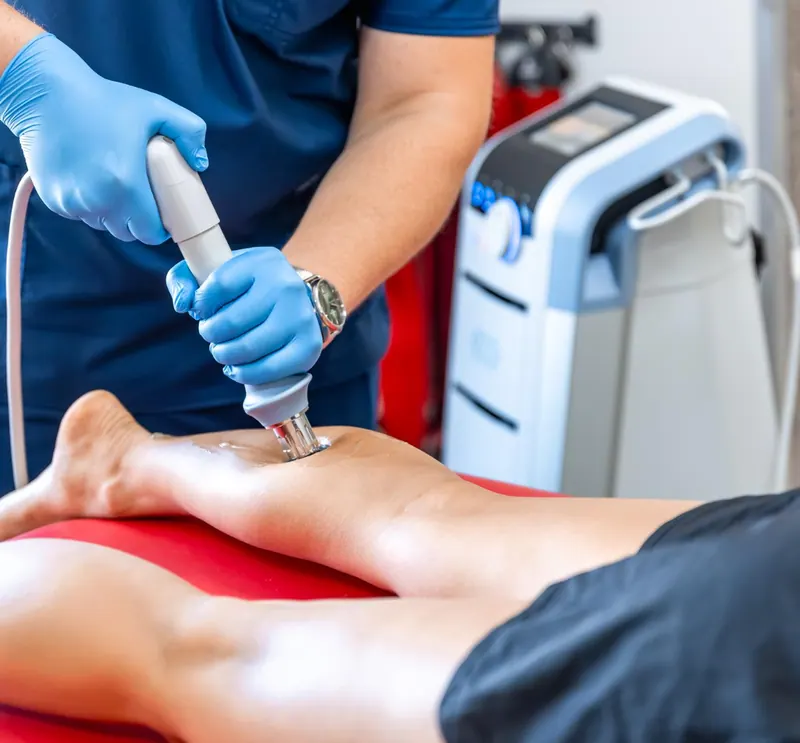 Clinician applying shockwave therapy to a patient’s heel